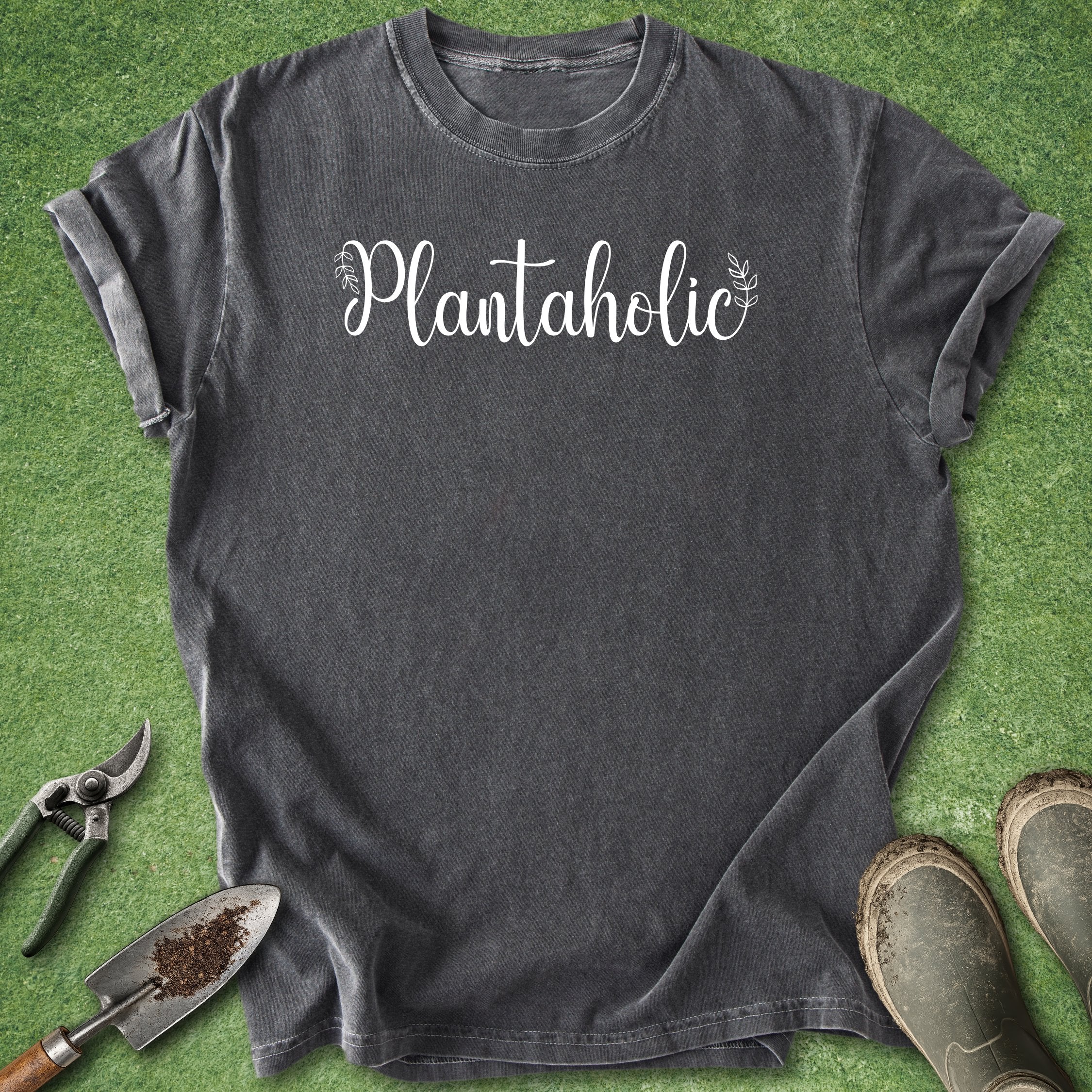 Black t-shirt with 'Plantaholic' text on a green grass background