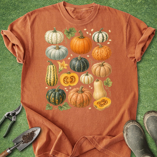 Rust orange t-shirt featuring a vintage botanical collection of pumpkins, gourds and squash in green, cream, yellow and orange autumn colors.