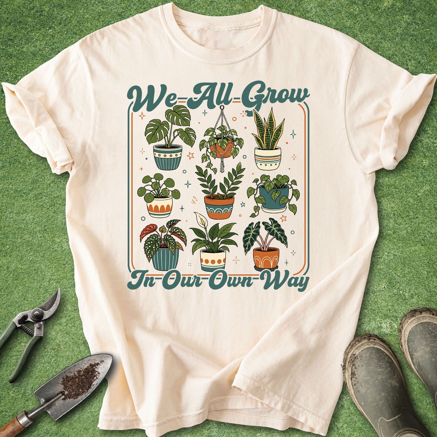 Cream gardening t-shirt with We All Grow in Our Own Way text and colorful retro potted houseplant illustrations.