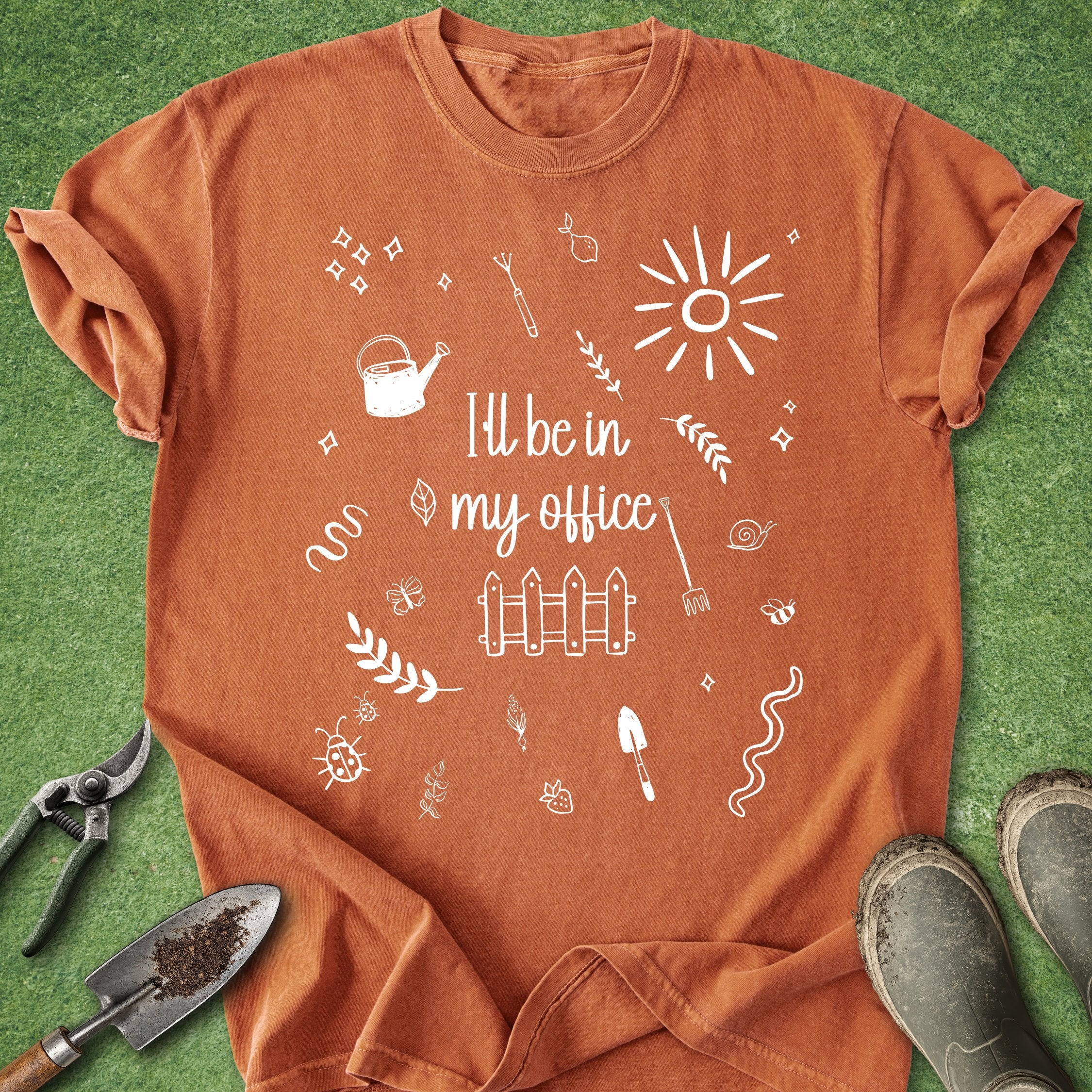 Orange t-shirt with white graphics and text on a green grass background