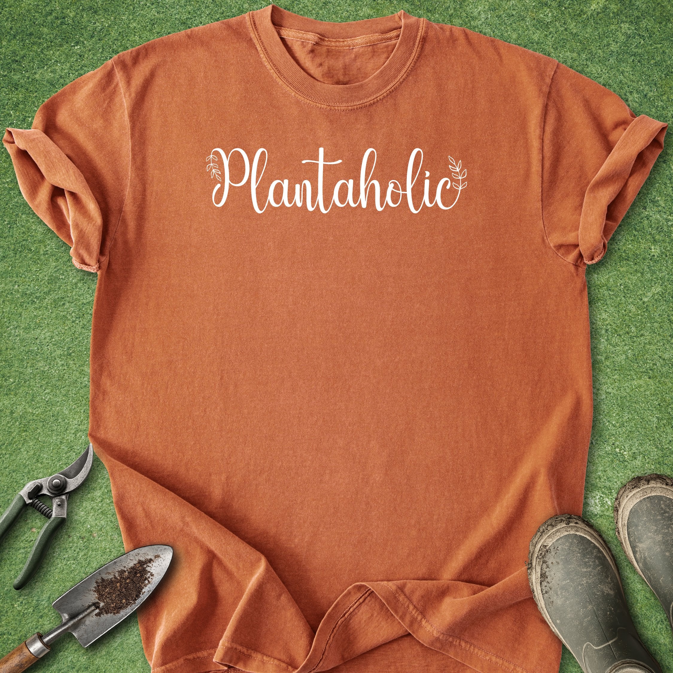 Orange t-shirt with 'Plantaholic' text on a green grass background